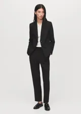 Pantalón de vestir tiro medio con diseño recto y trabillas para cinturón. Cuenta con bolsillos laterales y dos bolsillos de ribete en la parte posterior, con cierre oculto de botón, gancho y cremallera.