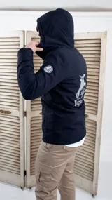 Campera parka azul marino con capucha, cierre frontal con cremallera y broches a presión, bolsillos laterales con solapa y puños ajustables con broches. Estampado en la espalda con un jinete a caballo y la inscripción "Bagual".