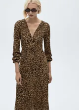 Vestido largo de tejido fluido con estampado animal print de leopardo. Presenta escote de pico, diseño recto y mangas largas con puños elásticos.