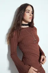 Vestido corto de manga larga acampanada, color marrón óxido, con textura acanalada y terminación ondulada en el ruedo.