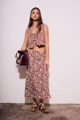 Chaleco marrón con estampado de hojas blancas, escote en V y lazos ajustables en el frente.