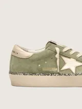 Zapatillas Hi Star de Golden Goose con empeine de gamuza verde militar, estrella lateral y contrafuerte en cuero metalizado dorado, plataforma alta con canto revestido en glitter y cordones de algodón crudo.