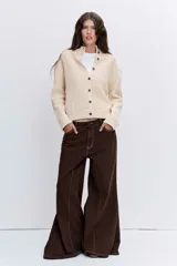 Cardigan de punto acanalado en color crema, con cuello redondo, cierre frontal de botones y mangas largas.