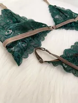 Conjunto de lencería compuesto por un bralette de encaje verde esmeralda con cierre frontal de gancho y una tanga regulable a juego. Ambas piezas presentan detalles en color marrón.