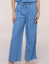 Pantalón fluido de estilo pull-on y silueta amplia confeccionado en lyocell de tacto sedoso, color azul. Cuenta con cintura totalmente elastizada con cordón ajustable, amplios bolsillos delanteros aplicados tipo parche y pierna de corte ancho y recto terminada con dobladillo deshilachado.