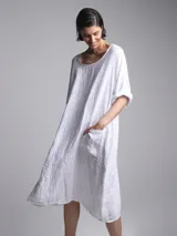 Vestido blanco tizado con bolsillos laterales.