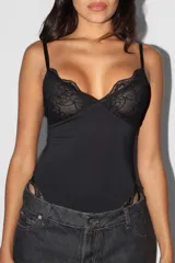 Body negro con breteles finos, parte superior de encaje y parte inferior lisa.