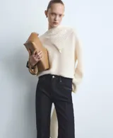 Pantalón de jean azul oscuro de corte flare, tiro medio y estilo clásico de cinco bolsillos.