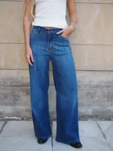 Pantalón jean de tiro medio, corte recto y amplio con caída estilo wide leg, en tono azul clásico.