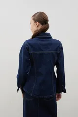 Chaqueta de denim de algodón con corte entallado en la cintura, cuello clásico, cierre frontal con botones metálicos y dos bolsillos con solapa en el pecho.