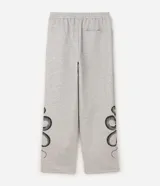 Pantalón de corte super baggy confeccionado en tejido de algodón y poliéster, color gris melange. Presenta un diseño urbano con estampado de serpiente tribal en color negro en las piernas, cintura elástica y bolsillos laterales.