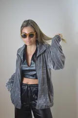 Campera gris de terciopelo con cierre frontal, cuello alto y mangas largas con puños elásticos.