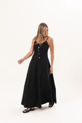 Vestido largo de denim fino y liviano color negro, de breteles finos, escote delicado, silueta entallada arriba y falda amplia con bolsillos laterales.