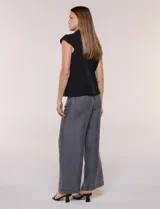 Chaleco sastrero negro de calce estructurado, con escote en V, solapa clásica, hombro caído con mangas integradas y acceso frontal mediante un único botón forrado a tono. Cuenta con bolsillos y ruedo recto.