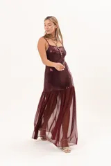 Vestido largo bordó con acabado brillante en el torso y tirantes finos, con falda larga semitransparente de tejido de red.