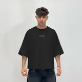 Remera de corte boxy fit color beige, con estampa gráfica en la espalda en color marrón que incluye el logo de la marca y texto descriptivo.