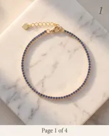 Pulsera de plata 925 con baño dorado, decorada con circonias azules en todo su contorno y cierre de mosquetón con cadena de alargue y dije de corazón.