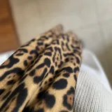 Bufanda larga con estampado de leopardo en tonos marrón y negro.