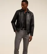Pantalón slim de sarga color beige, de corte ajustado, con cierre frontal de botón y cremallera, y bolsillos laterales tipo cuchillo.