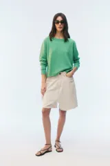 Sweater de tejido de punto verde, con calce regular levemente suelto, escote redondo y mangas largas con puños acanalados.