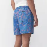 Short de baño Quiksilver modelo Volley Light Reflection, con diseño estampado multicolor en tonos azules y rosados, cintura elástica con cordón ajustable blanco y negro, y detalle de etiqueta con logo en el dobladillo.
