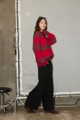 Sweater de tejido jacquard con diseño de rayas horizontales en tonos rojo y bordó, de corte holgado, cuello redondo y manga larga.