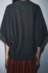 Jersey de punto liso con cuello redondo y mangas cortas anchas. Presenta acabados en rib en el cuello, puños y bajo.