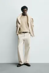 Sweater de punto color beige, de corte relajado, con cuello redondo y diseño texturizado en estructura waffle.
