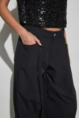 Pantalon negro de corte holgado y estilo cargo, con cintura elástica, bolsillos laterales y terminación ajustada en los tobillos.