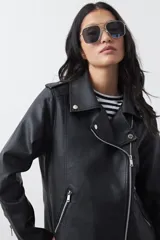 Campera biker de cuero sintético en color negro, con cierre diagonal, solapas amplias y herrajes metálicos plateados.