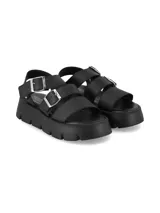 Sandalia Neva de cuero graneado color negro, con diseño chunky de tres tiras con hebillas metálicas plateadas, tira trasera y suela de poliuretano texturizada.