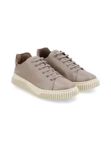 Sneakers de cuero graneado color taupe, sin forro, con suela elevada sintética y texturizada.