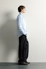 Camisa slim fit de algodón color celeste con sutil patrón de cuadros, cuello clásico y manga larga con puños abotonados.
