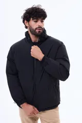 Campera puffer negra de corte estándar, con cuello alto, cierre frontal completo y puños elásticos.