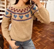 Sweater de punto color gris con diseño de corazones rosas y cuello con diseño geométrico.