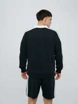 Buzo deportivo Umbro modelo Mixtape, color negro con cuello polo blanco y franjas blancas en las mangas con logo de la marca. Cuenta con puños y cintura elastizados.