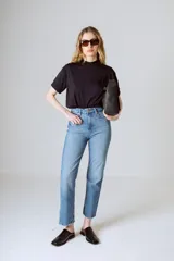 Camiseta básica de algodón orgánico color negro, con cuello redondo alto y mangas cortas con doblez. Incluye un pequeño bordado tono sobre tono de la marca en el pecho.