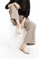 Mocasines de cuero color beige con costuras visibles y suela plana.