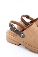 Zuecos de cuero color beige, con suela track y tira trasera ajustable.