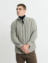 Camisa de franela lisa con cuello button-down, manga larga, bolsillo frontal y botones al tono.