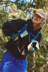 Buzo negro con capucha, cierre frontal, calce relajado y ligeramente holgado, con costuras definidas, hombros caídos y mangas levemente amplias.