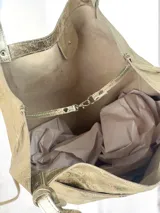 Bolso tote grande de cuero color dorado con efecto metalizado, doble asa de hombro y bolsillo externo.