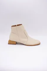 Botín de cuero dorado con punta fina y taco bajo cuadrado de madera.