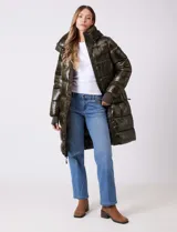 Campera puffer larga de abrigo marca BCBG Maxazria, color beige. Cuenta con capucha desmontable, cuello alto envolvente, cierre frontal bidireccional con solapa de botones a presión, bolsillos laterales, puños internos elastizados y tajos laterales con cierre en el bajo.