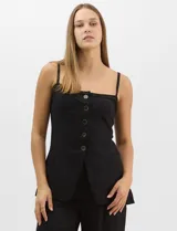 Conjunto monocromático compuesto por un top de breteles finos con escote recto y cierre frontal de botones, y un pantalón de tiro alto con pierna amplia y bolsillos laterales.