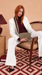 Bandolera compacta de diseño moderno, confeccionada en símil cuero color verde oliva. Cuenta con cierre superior, correa regulable y logo de la marca grabado en el frente.