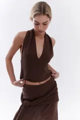 Top bordó de punto con lurex, escote en V profundo estilo halter y diseño sin mangas.