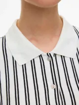 Cardigan de manga larga con cuello camisero y cierre frontal de botones. Presenta un diseño de rayas verticales en contraste y está confeccionado en un tejido con mezcla de poliéster, viscosa y elastano.