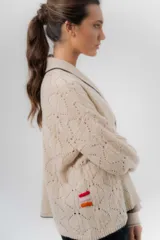 Saco tejido de lambswool color marrón, con diseño inspirado en kimono, mangas largas y delicados calados en toda la prenda. Cuenta con bordes en contraste.
