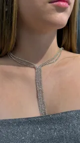 Gargantilla tipo choker de estilo y-necklace, compuesta por múltiples hileras de strass brillante que se unen en el centro para formar una caída vertical.